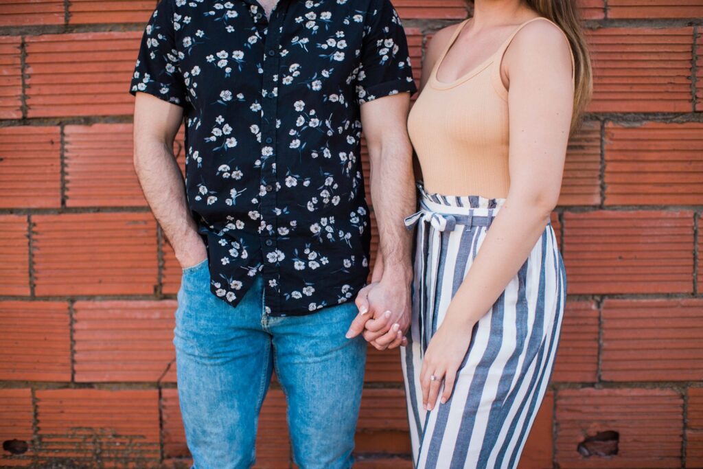Liz and Ruben engagement hands on red brick wall downtown New Braunfels