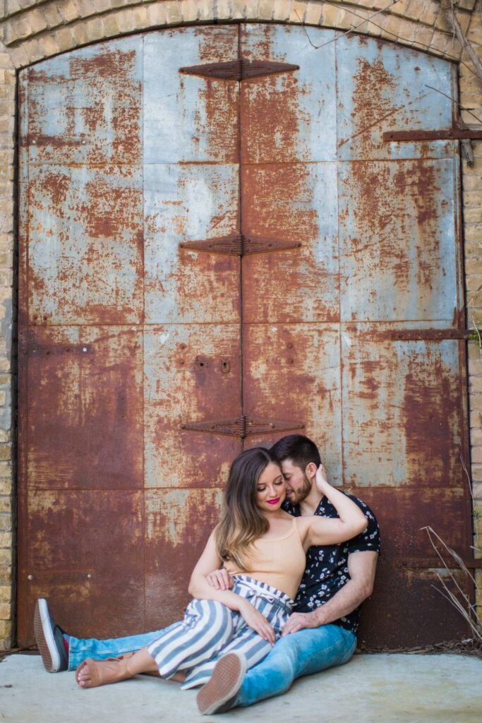 Liz and Ruben engagement rusted wall snuggling downtown New Braunfels