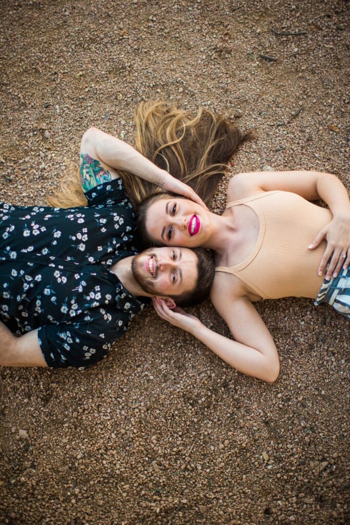 Liz and Ruben engagement square laying on gravel down downtown New Braunfels