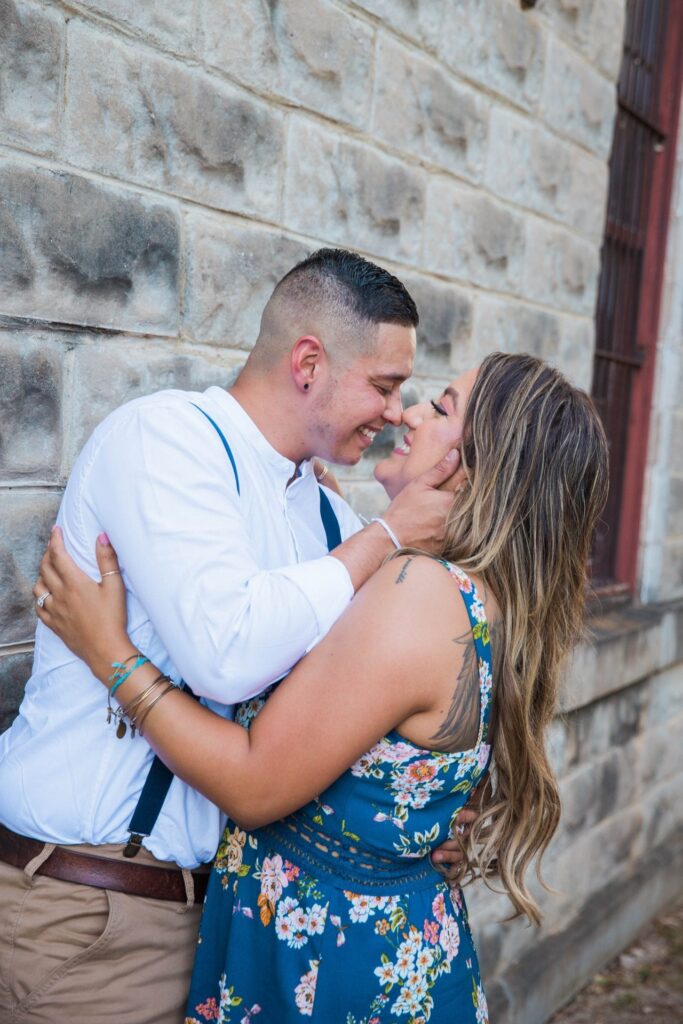 Ashley and Andy's engagement session Gruene brick wall kiss
