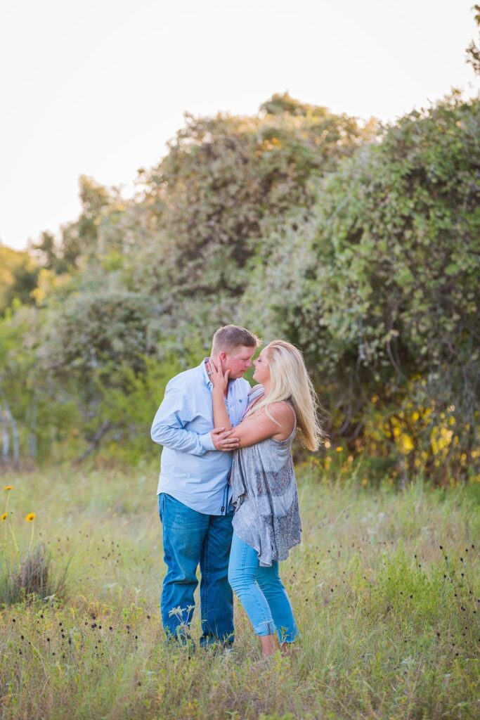 Whitney and Craig's ranch Engagement session tall grass foreheads touching