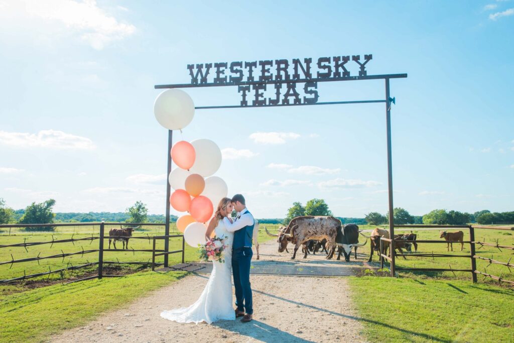 Western Sky Styled shoot couple with cows at gate