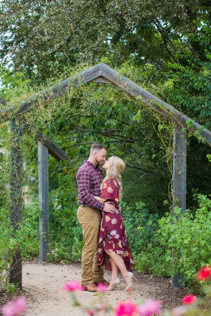 Molly's engagement Texas a and M wooden arch hug and kiss