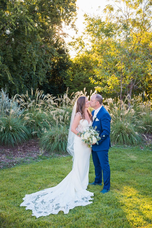 David and Angie wedding at The Kendall Inn bride and groom by pampas grass kiss