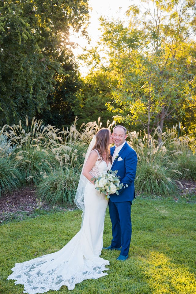 David and Angie wedding at The Kendall Inn bride and groom by pampas grass her kissing him