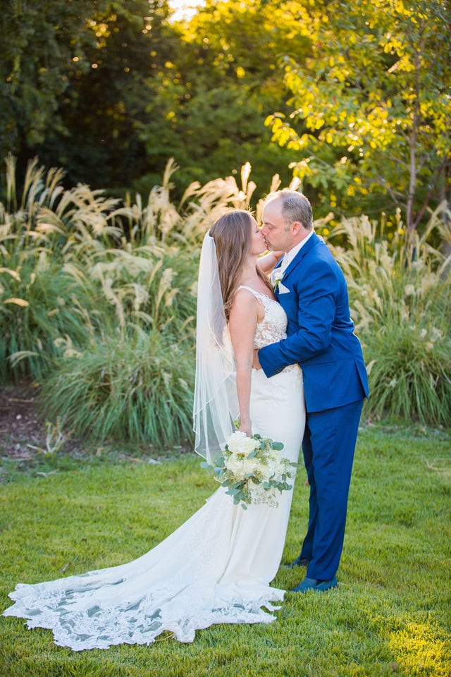 David and Angie wedding at The Kendall Inn bride and groom by pampas grass big kiss