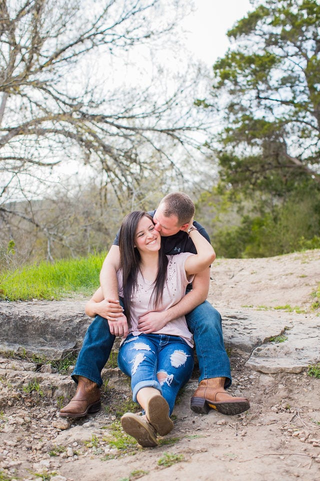 Stefan and Ashley's engagement session. Couple laughing on the boulder