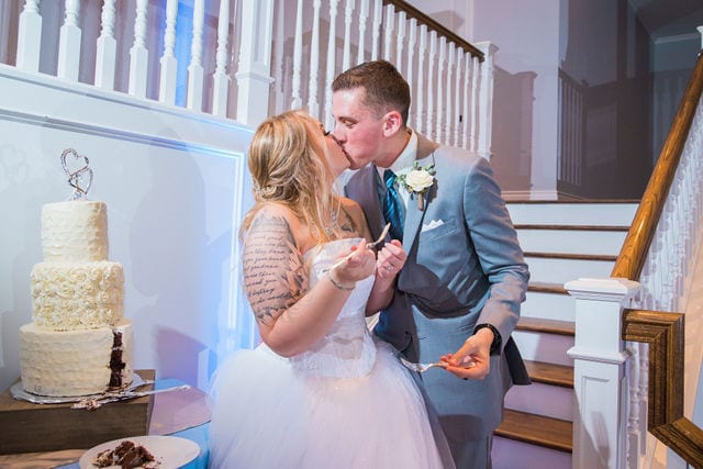 Kristina and Brandon's Wedding at Kendall plantation cake cutting kiss