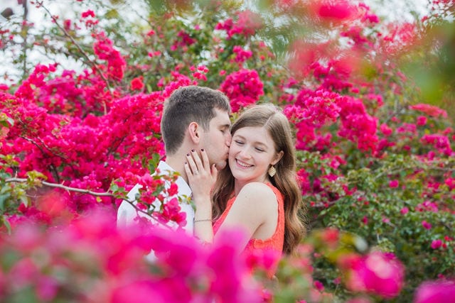 Claire & Josh engagement session San Antonio Botanical Gardens in the plants on top of the hill cheek kiss
