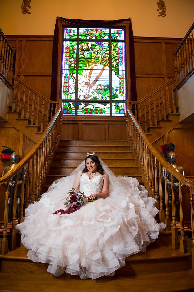 Emilia's Bridal in the ballroom at Castle Avalon seated on the staircase