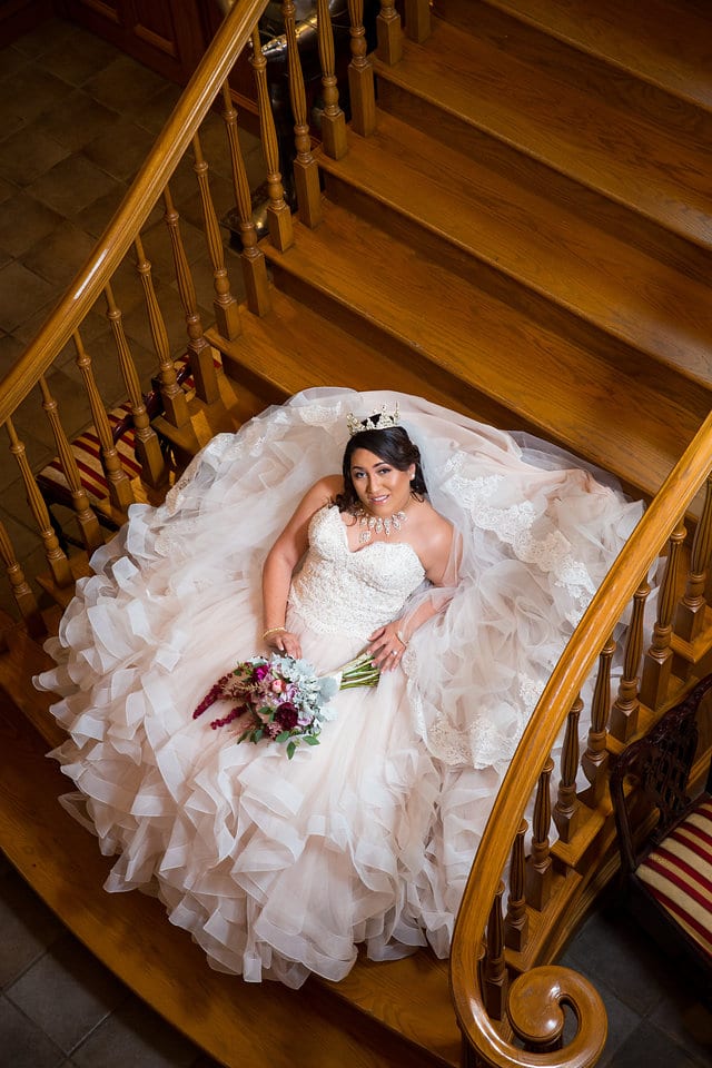 Emilia's Bridal in the ballroom at Castle Avalon laying on the staircase from above