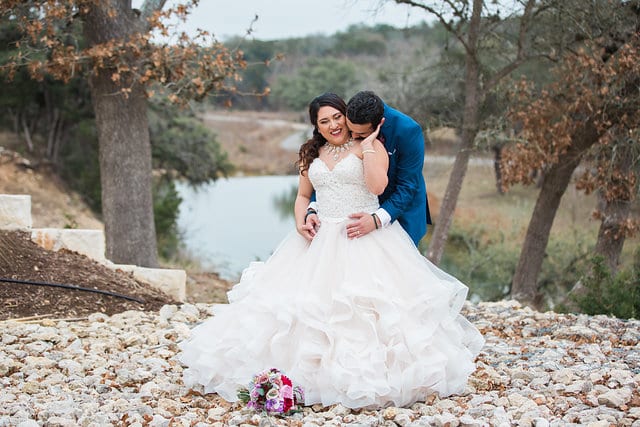 Emilia and John wedding The Milestone Boerne couple snuggled by the river laughing