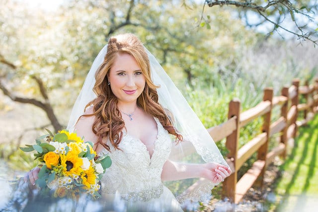 Jamie's Bridal at the Milestone in Boerne portrait by the fence close up holding veil
