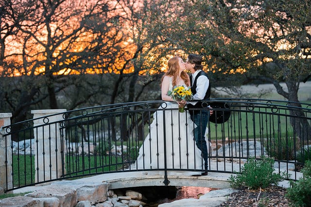 Jamie's wedding at the Milestone in Boerne the couple on the bridge at sunset kissing