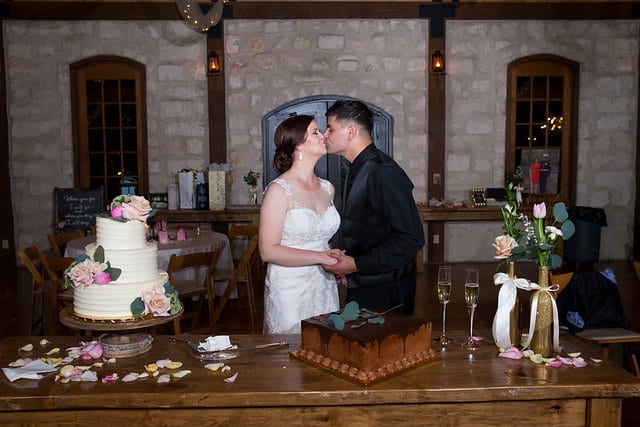 Katie Z wedding at tThe Milestone New Braunfels reception cake cutting kiss