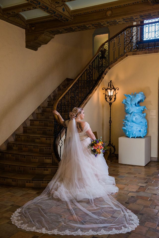 Katie's Bridal session at the McNay posed at the bottom of the stair case back of the dress