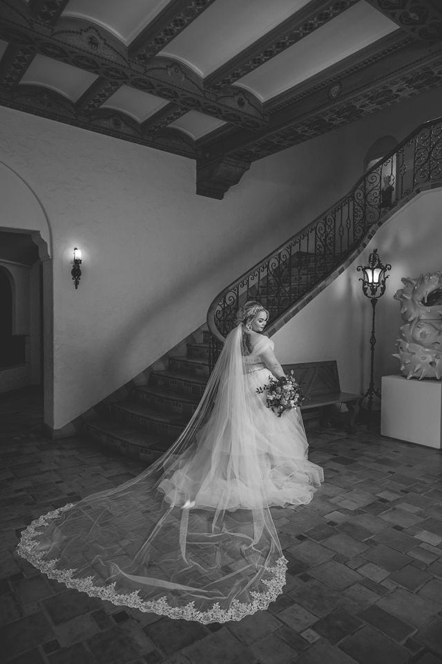 Katie's Bridal session at the McNay posed at the bottom of the stair case back of the dress black and white
