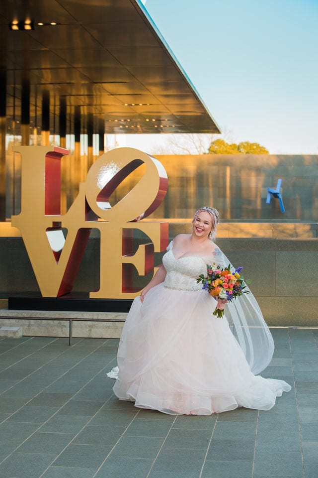 Katie's Bridal session at the McNay walking with the LOVE sign laughing