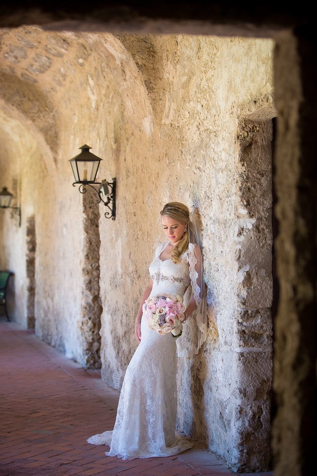 Kimb bridal at Mission Conception bridal leaning by the wall looking down