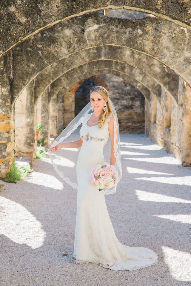 Kimb bridal at Mission San Jose portrait in the arches holding veil