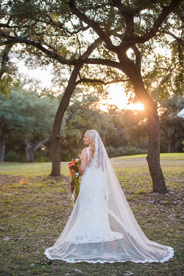 Whitney's Bridal portrait the Chandelier of Gruene in the trees at sunset back of dress looking away