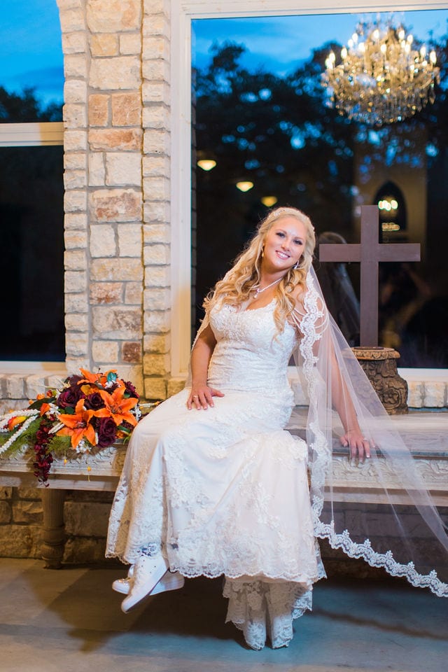 Whitney's Bridal portrait the Chandelier of Gruene in the chapel sitting on the table blue sky