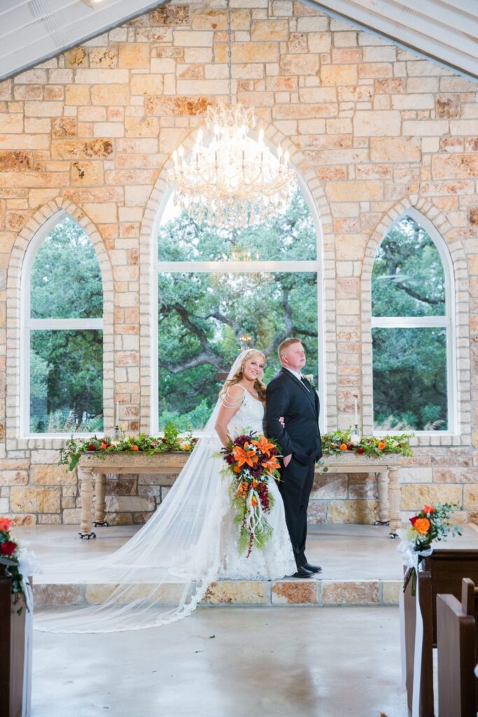 Whitney wedding Chandelier of Gruene the couple in the chapel his back to her