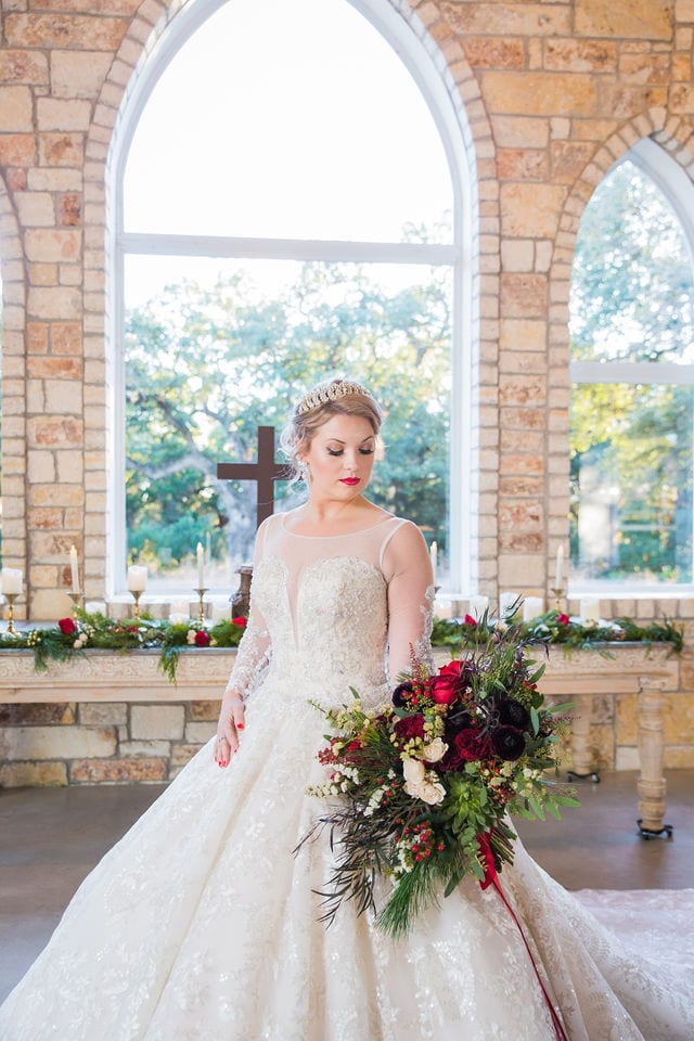 Styled shoot Chandelier of Gruene Christmas Bride with her bouquet in the chapel