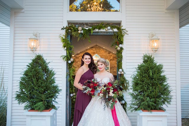 Styled shoot Chandelier of Gruene Christmas Bride and bridesmaid in the doorway