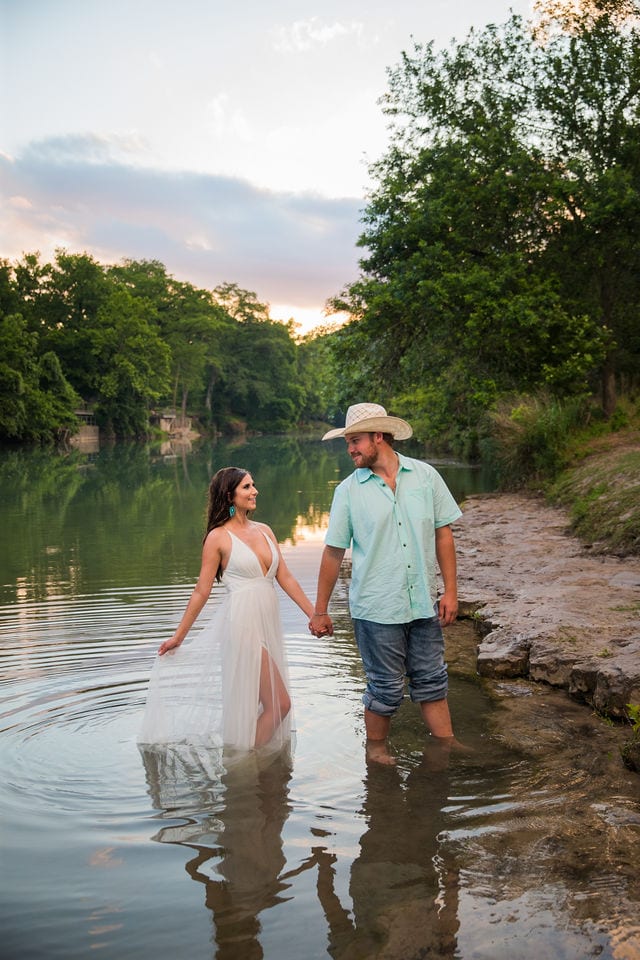 Hand engagement in the river dress floating at sunset