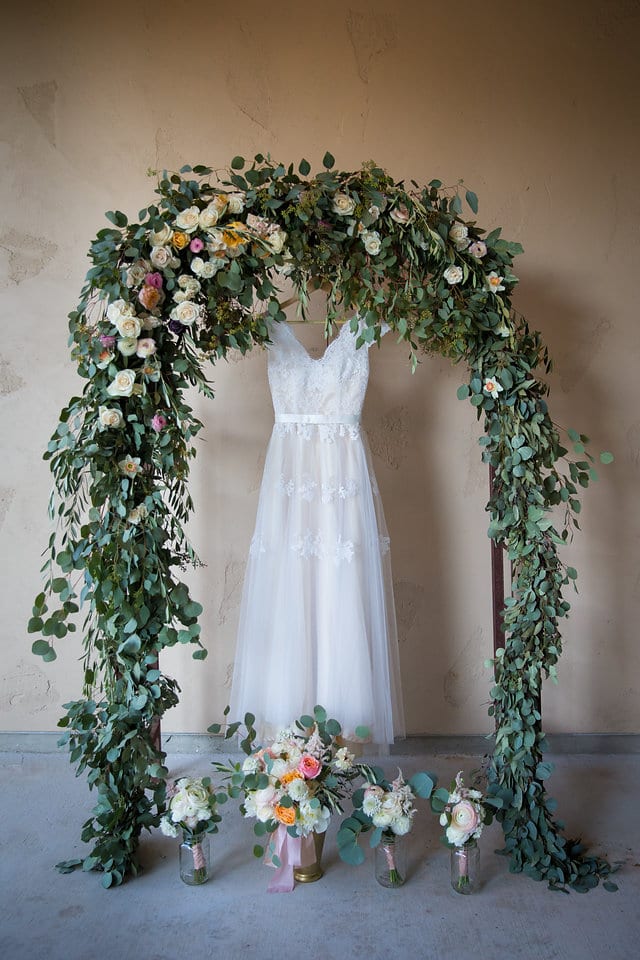 White wedding Gown in the ceremony a foral arch