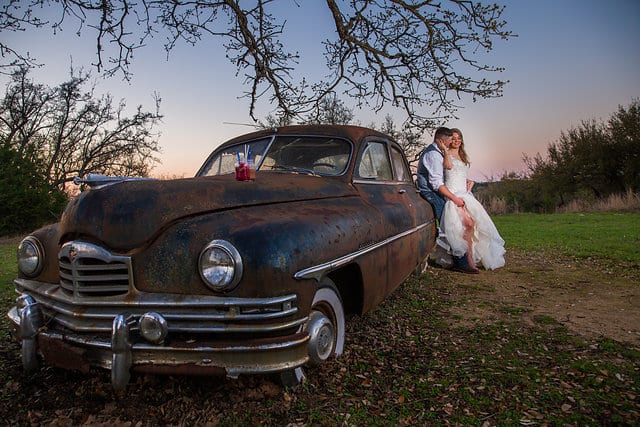 Chelsea and Tyler's Wedding, bride and groom portrait with rustic car