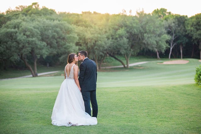 Styled wedding shoot at Olympia Hills San Antonio bride and groom on the green in the sun kissing