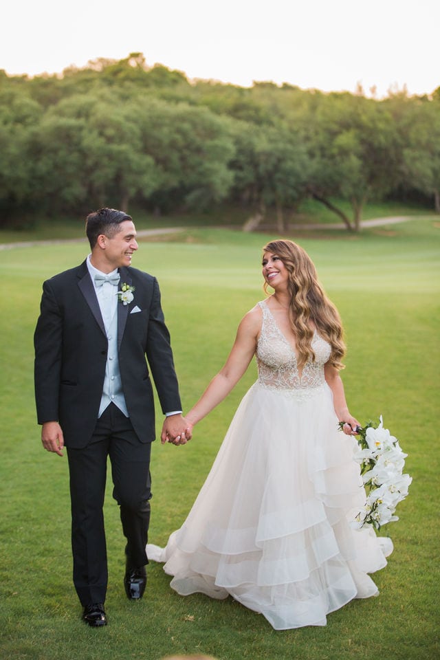 Styled wedding shoot at Olympia Hills San Antonio bride and groom walking on the green