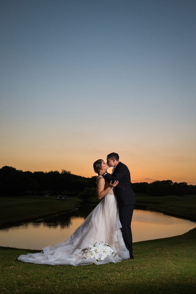 Styled wedding shoot at Olympia Hills San Antonio bride and groom kissing by the pond at sunset