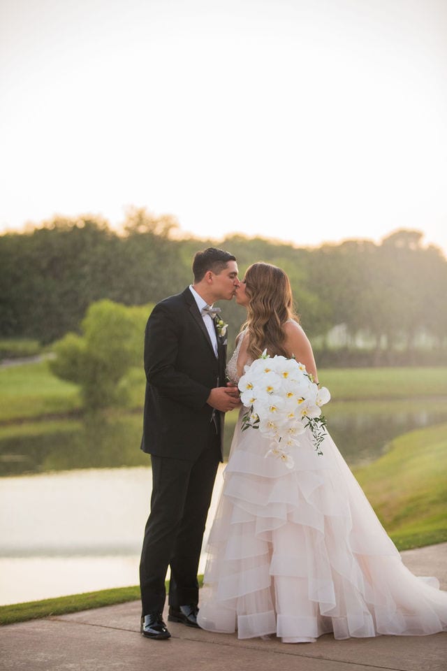 Styled wedding shoot at Olympia Hills San Antonio bride and groom kissing by the pond water