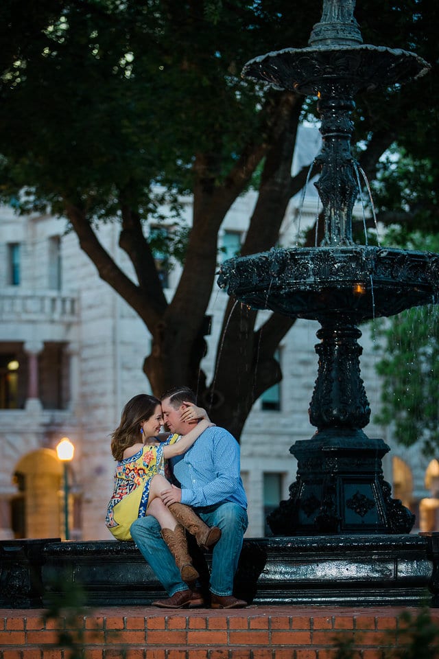 Grisham engagement portrait huggling by fountain
