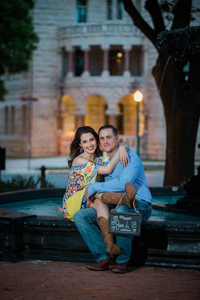 Grisham engagement portrait with sign by fountain