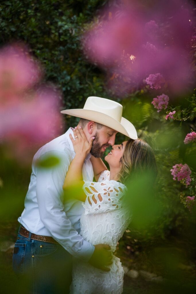 Kleiman engagement in Gruene pink flower kissing