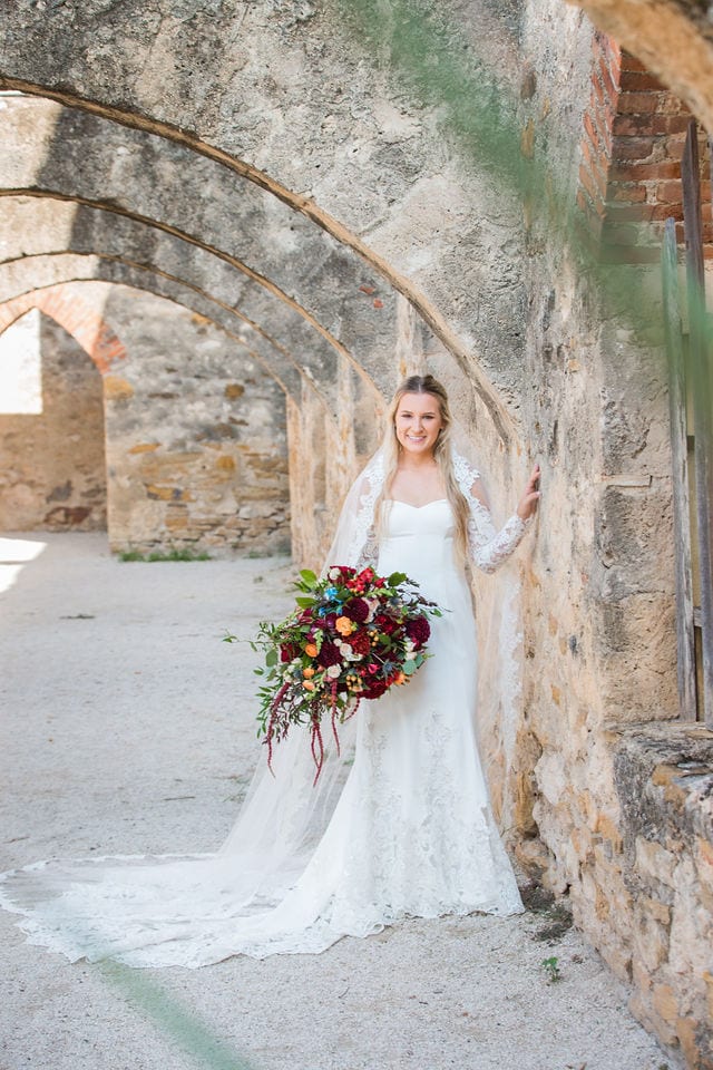 Kelsey's bridal at Mission San Jose in the arches with flowers