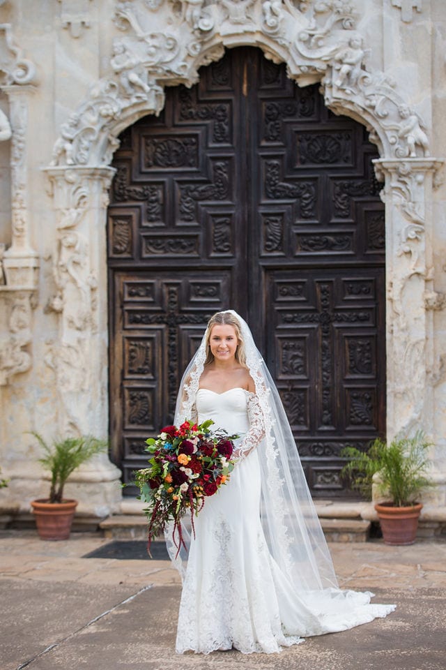 Kelsey's bridal at Mission San Jose large doors with a bouquet portrait