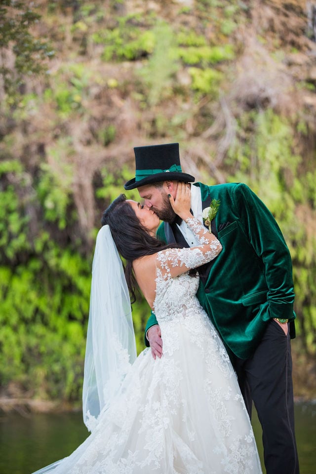 Bride and groom kissing at Canyon Springs by the waterfall during wedding