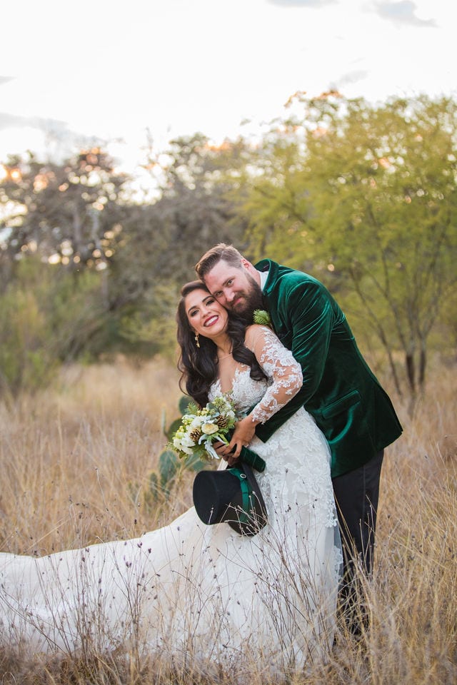 Bride and groom in the grass cuddling at Canyon Springs wedding