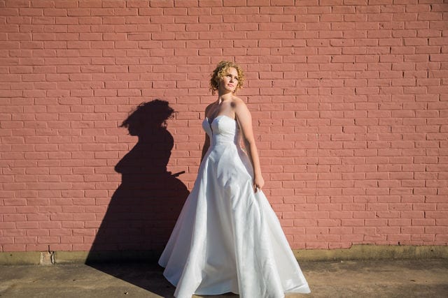 I do the dress I Do bridal gown on brick wall portrait