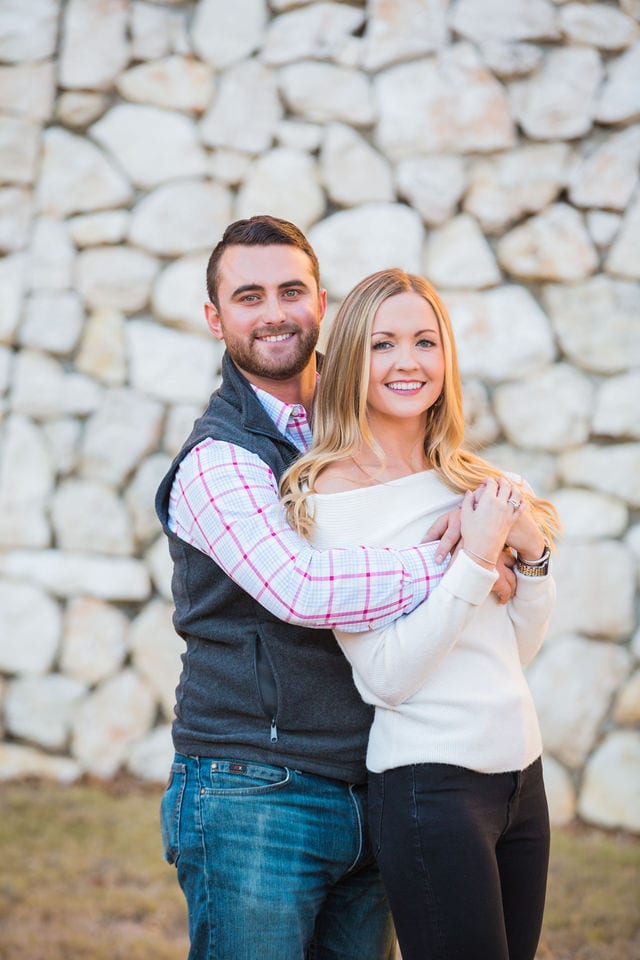 Engagement photography at JW Marriott couple by the stone wall hugging