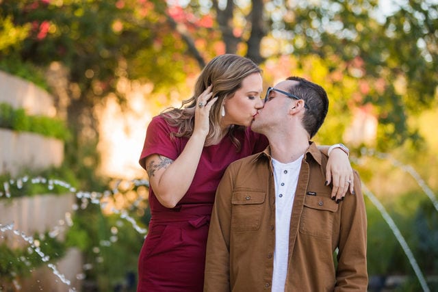 Weber couple at San Antonio Botanical Gardens by the fountain kiss