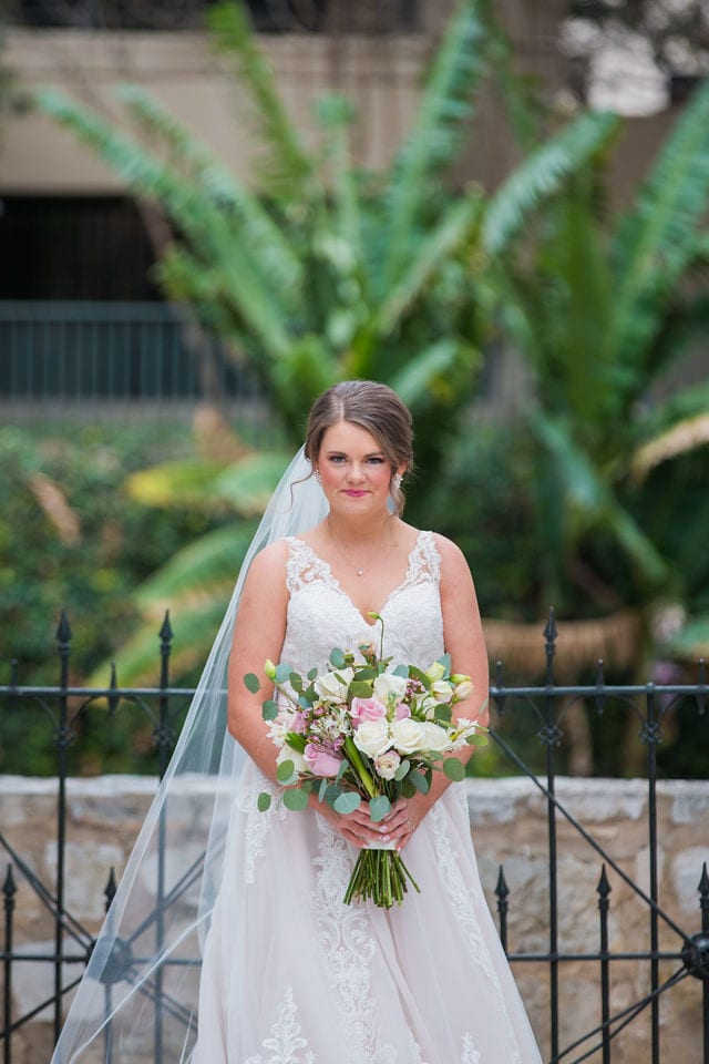 Erin bridal with bouquet at the gate at Southwest School of art San Antonio