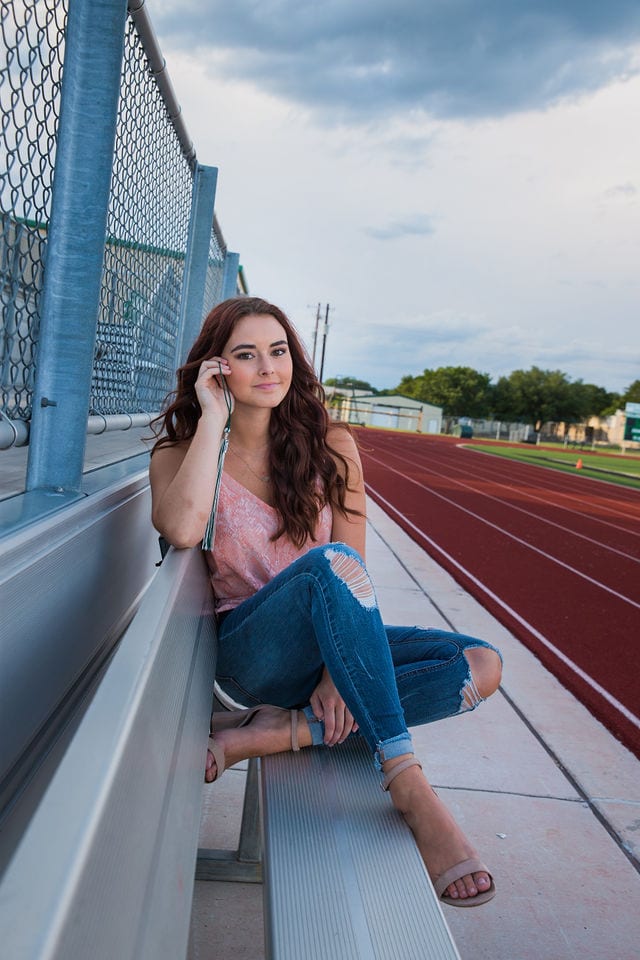 Faith Senior session curled up on the bleachers in Marion