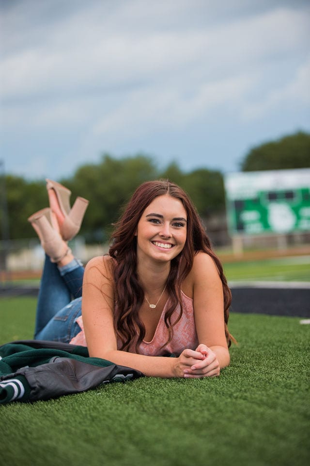 Faith Senior session in Marion letterman on the field laying