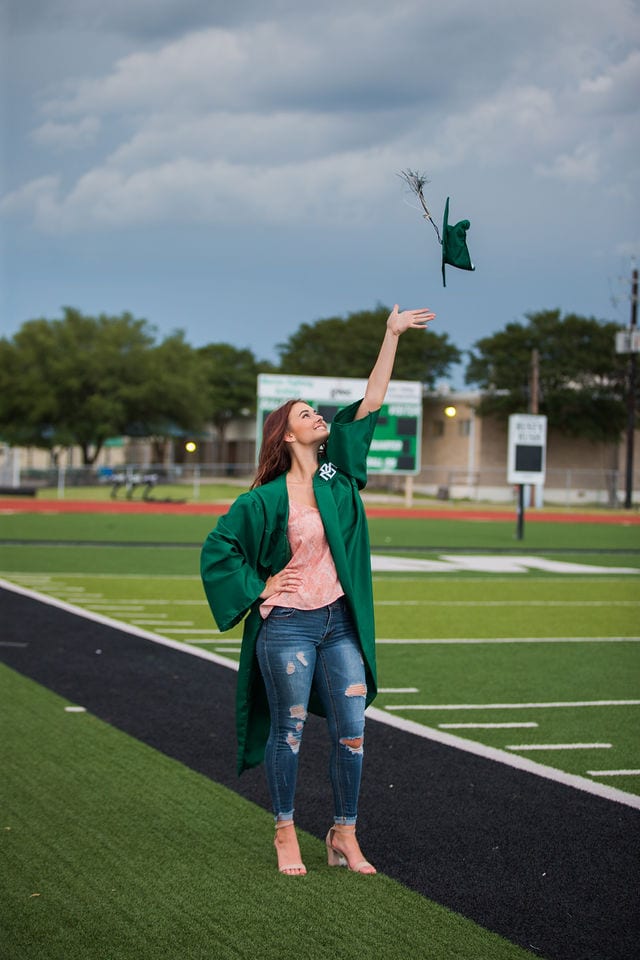 Faith Senior session in Marion tossing cap on the field